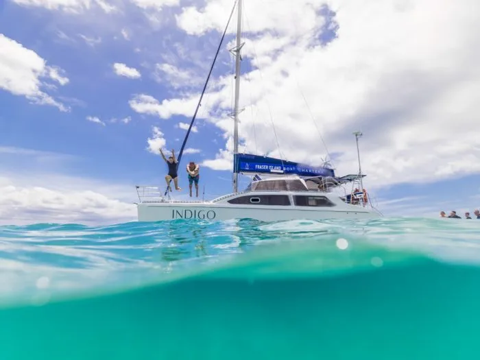 Guests jumping into the water while on a yacht charter